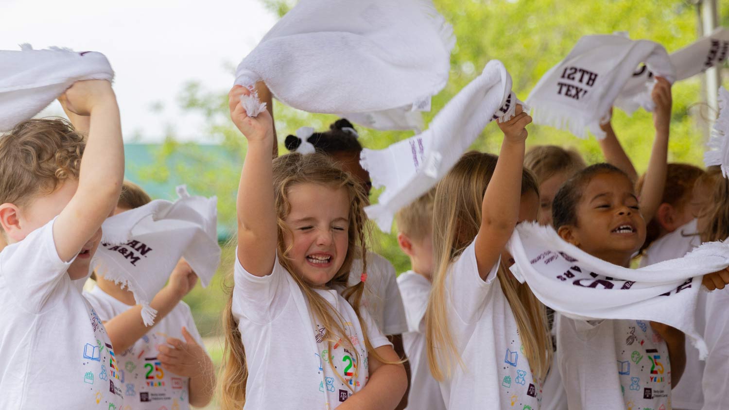 A group of pre-K students wave 12th Man towels at a children's event