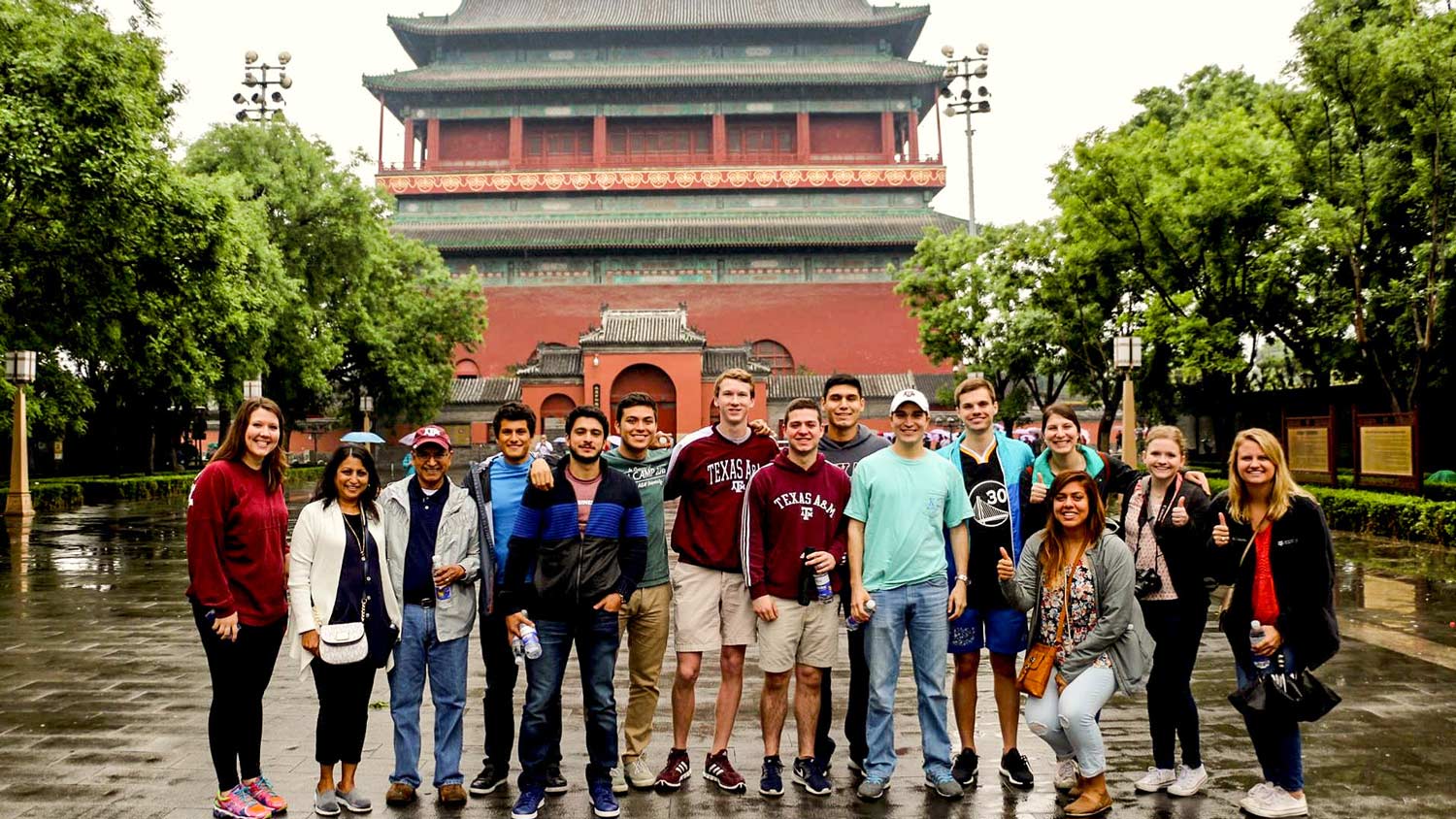 Study abroad students stand in front of an asian temple