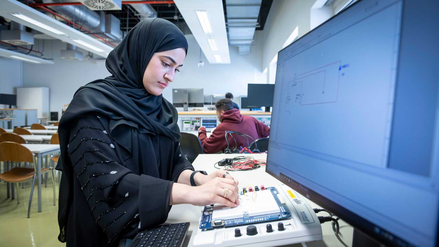 A student builds an electric circuit at the Texas A&M Qatar campus