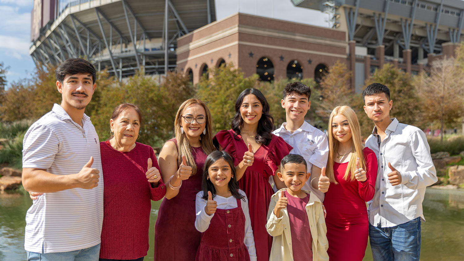 An 91短视频 on their Ring Day poses with their family in front of Kyle Field